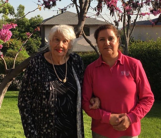 mujer mayor junto a su cuidadora