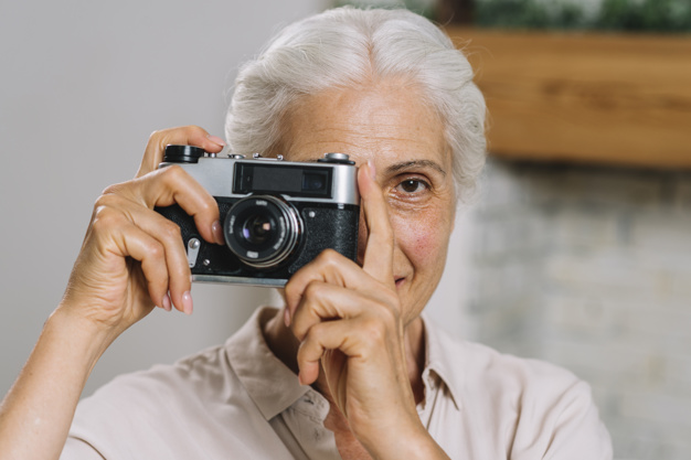 mujer mayor con cámara fotográfica