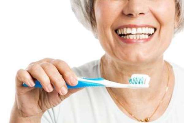 mujer mayor cepillándose los dientes
