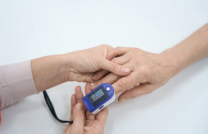 Enfermera realizando medición con oxímetro de pulso